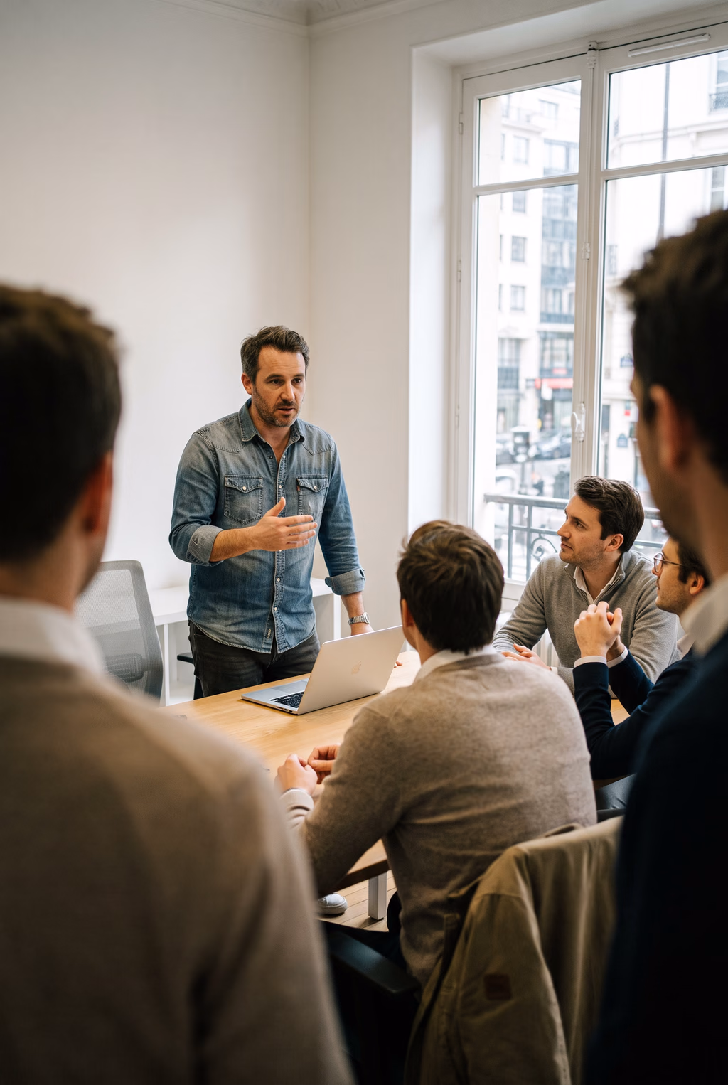 A founder talking a small team through the quarter's numbers in a bright meeting room.